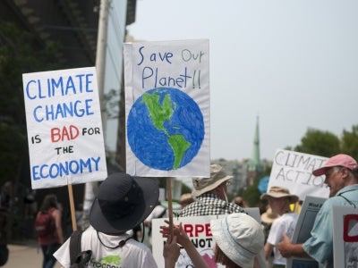 Protesters with signs urging to save the planet with climate control. July, 2015, Toronto, Canada.