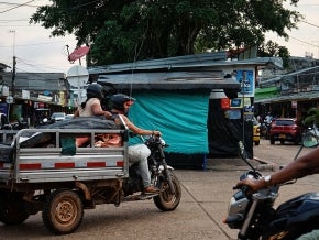 People on various forms of motor transport in a city setting