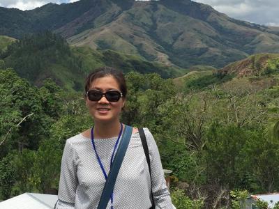 Seo-Jeong Yoon in front of a mountain and forest landscape in Navilawa village in Fiji