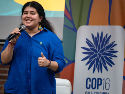 Woman in blue shirt speaking at an event
